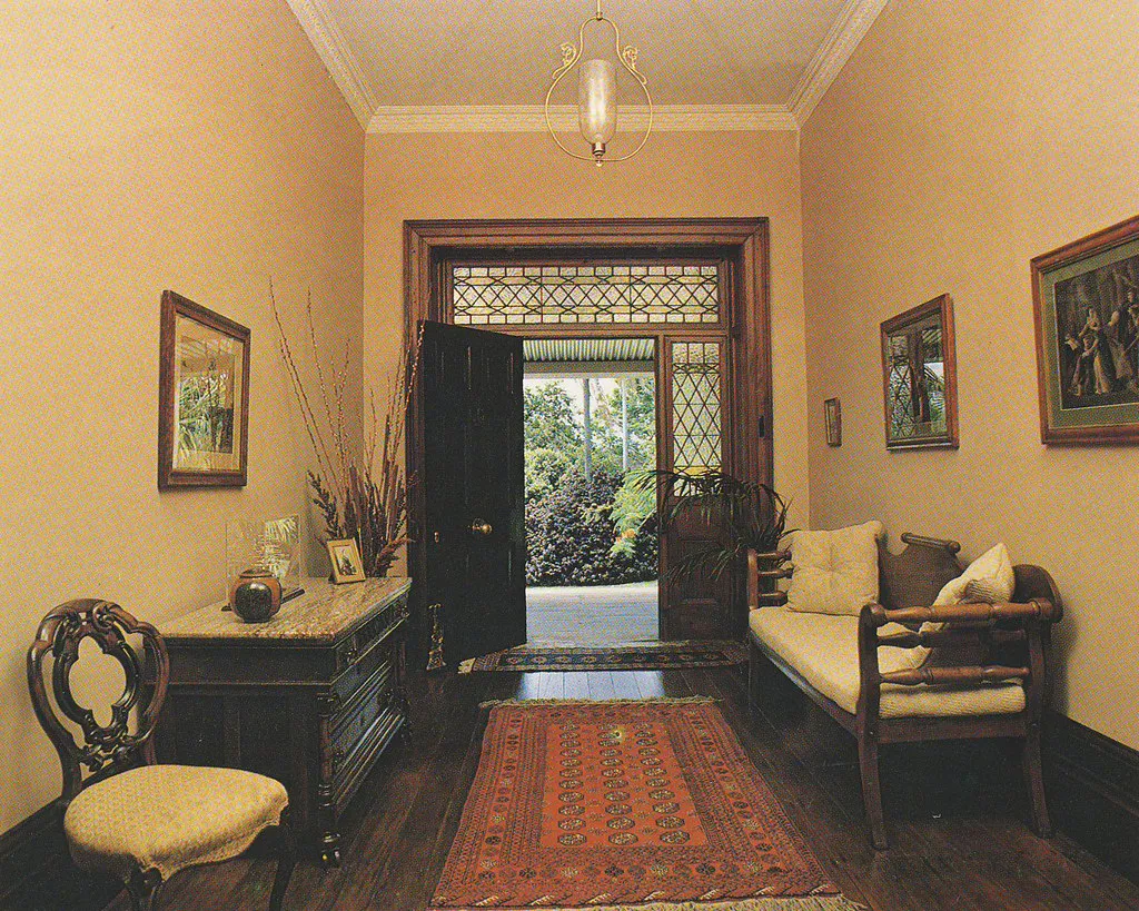 Entry hall with a dark wood floor, runner rug, and open front door