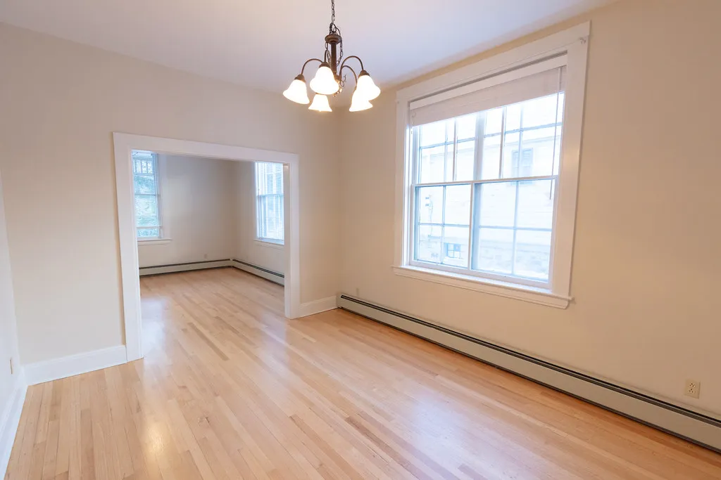 Refinished original hardwood floor in an empty room of an older home