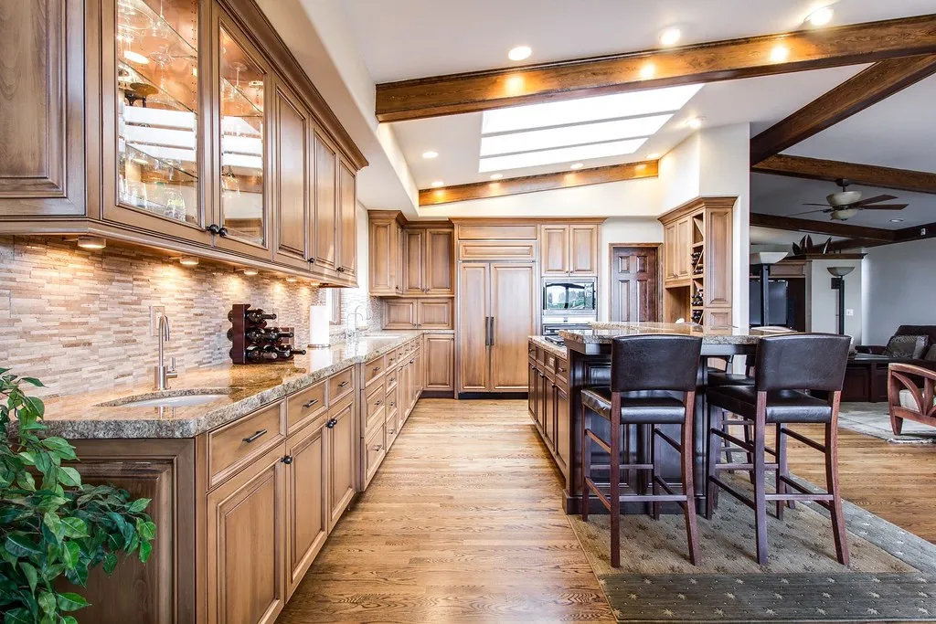 Kitchen with hardwood flooring running past the sink and island